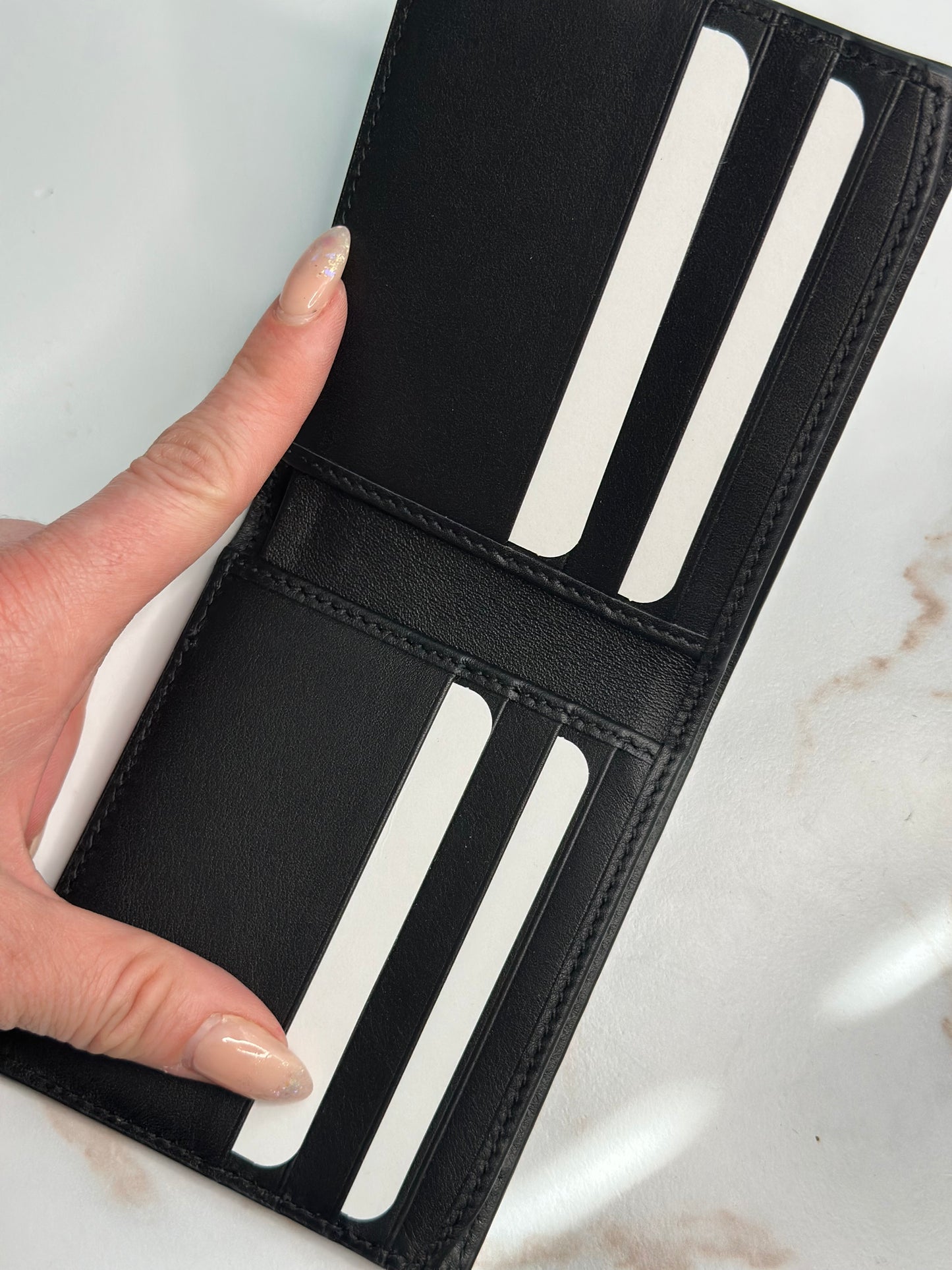 Pre-owner Gucci GG embossed black bifold wallet
